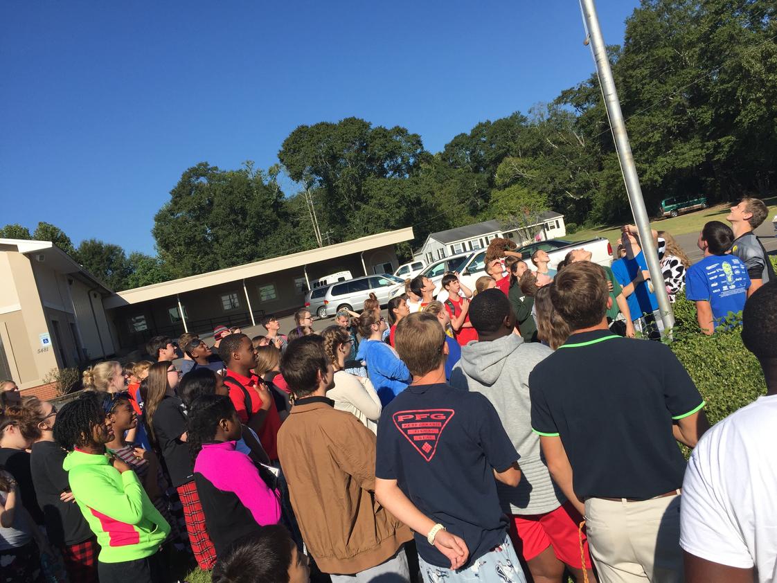 Victory Christian Academy Photo - Students gather around the flag pole to pray for our country.