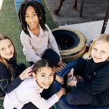 The Wesley School Photo #7 - A group of 3rd graders find comfort and fun in spending time together outside playing and collaborating.