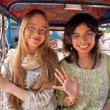 Living Wisdom School Of Palo Alto Photo #3 - Two Living Wisdom students smile and wave while riding in a colorful bicycle rickshaw during a school travel experience in India.