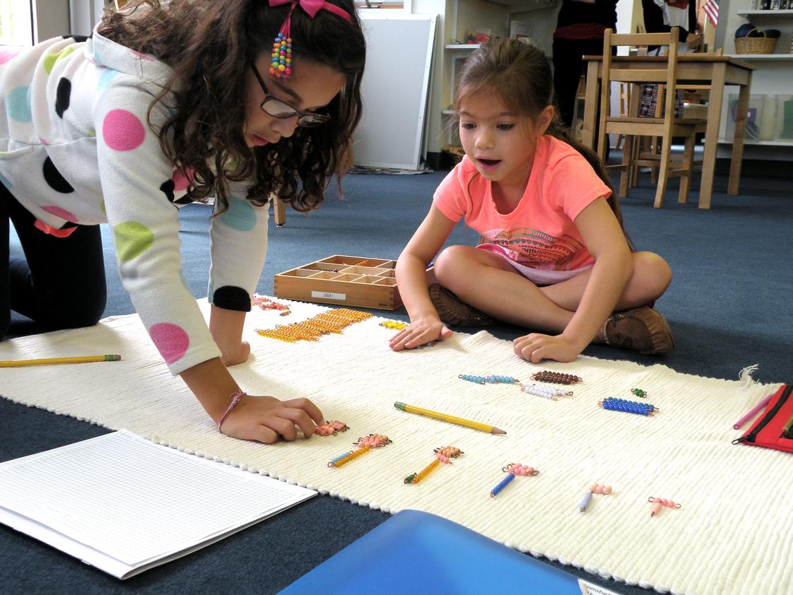 Princeton Montessori School Photo - Elementary students work collaboratively on a math layout using Montessori materials and our hands-on approach.