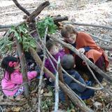 Barnert Temple Preschool Photo #2 - Students venture into the surrounding forest each week for exploration and adventure. Here they built a structure and invite the Rabbi in for a visit.