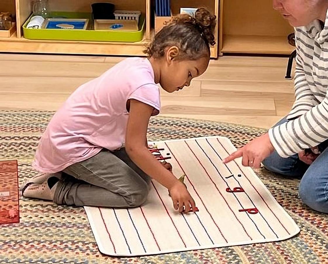 Santa Rosa Montessori Photo #1 - Sounding it out and building words! This 3.5-year-old is making words with material designed to support early writing skills. Montessori makes early literacy fun and hands-on.