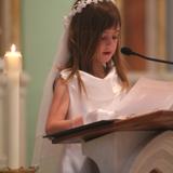 Immaculate Heart Elementary School Grades Photo #4 - An IHC Primary School student conducts a reading at the school's May Crowning celebration, a special IHC tradition. Students participate in a procession of flowers, scripture readings, prayer, and song. At the High School, the ceremony ends with the crowning of the statue of Mary in front of the school.