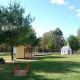 Thevenet Montessori School Photo #3 - Our outdoor playground is a village of eight beautiful wooden buildings, the perfect size for our students. We have a schoolhouse (complete with bell), peace chapel, barn, post office, deli and four houses.