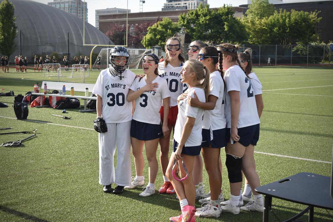 St. Mary 's Academy Photo #3 - Senior lacrosse players signing the national anthem during their senior night game.