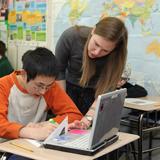 Edison High School Photo - A student works with history teacher Ms. Connolly during class. Every incoming student receives a laptop (now an iPad) equipped with assistive software.