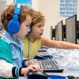 The Nysmith School Photo #7 - Preschool teamwork in action! One student helps her classmate with a coding assignment, programming a chicken to navigate through different squares to reach the correct spot. Early coding skills and collaboration at their finest!