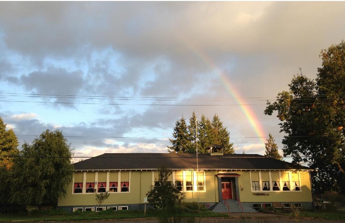 Olympia Waldorf School Photo - A rainbow rises over the historic main schoolhouse, which has been home to Olympia Waldorf School for over 35 years. The campus also includes a separate Middle School building for grades 6-8, and a residential kinderhaus at the far north side of the property.