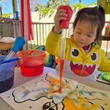 OC Kids Infant & Preschool Photo #8 - Water Color Painting in our Outdoor Art Center. Along with Outdoor Art OC Kids has an Outdoor Science Center and Garden Areas. We believe that providing children with a variety of learning spaces breaks up their day for learning, gives all children the optimum space for learning, and also provides a space for teachers to get extra messy and handson.