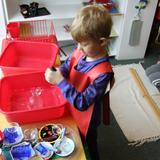 The Happy Childrens Montessori Photo #3 - A boy doing the dishwashing work.