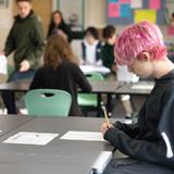 West Sound Academy Photo #12 - A student takes time to reflect before writing his response in a busy 9th-grade classroom