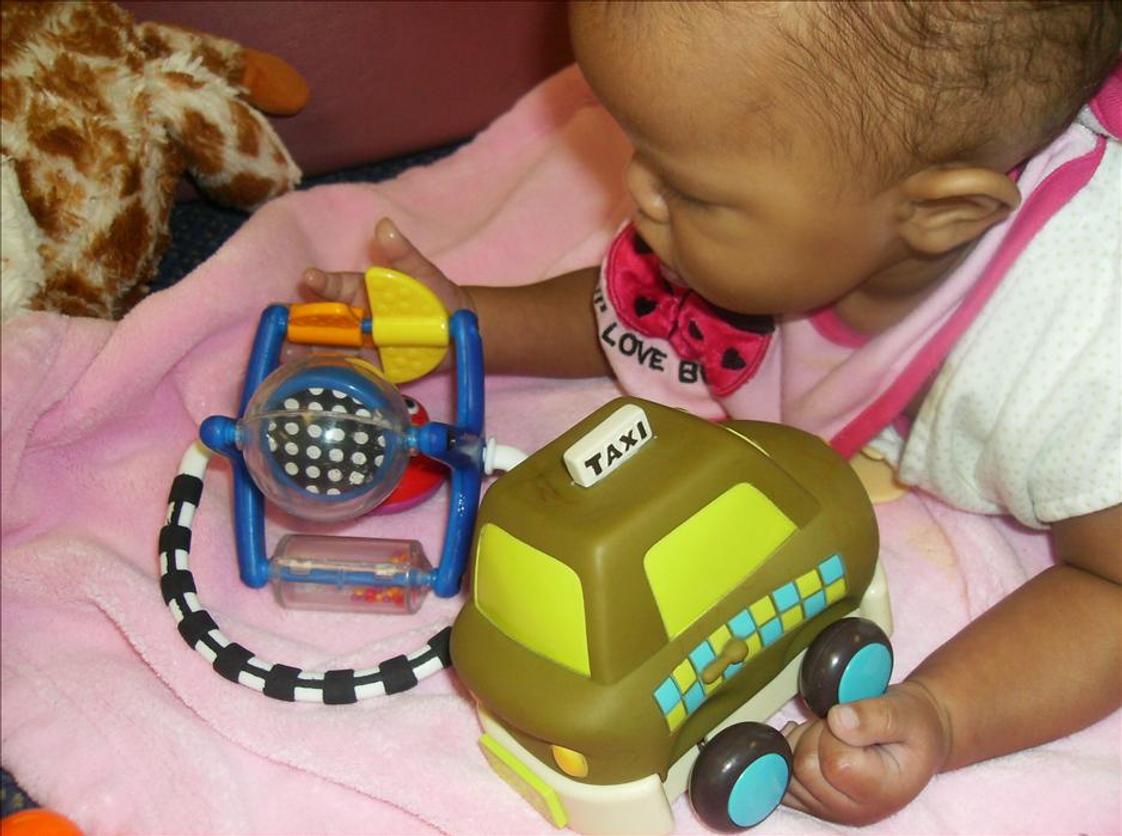 Matteson KinderCare Photo - Infant Classroom exploring her fine motor skills