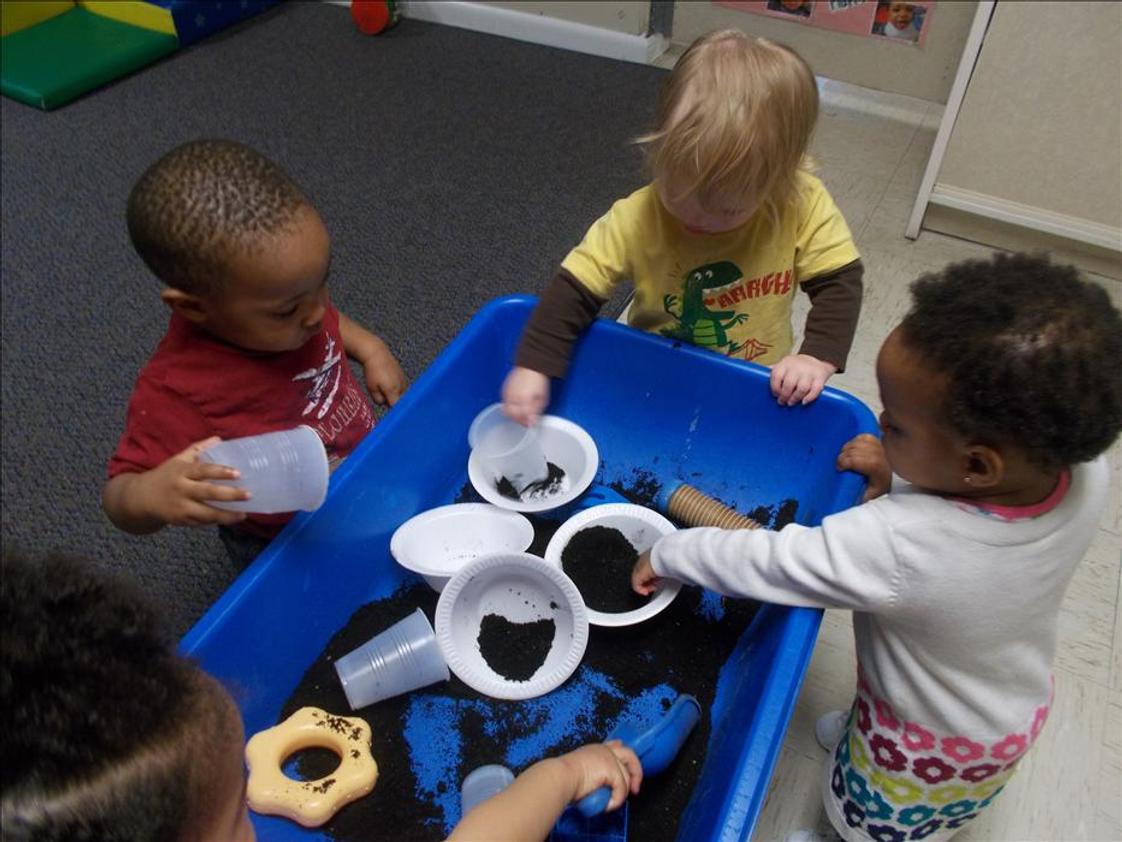Fordson Road KinderCare Photo #1 - Toddler Science - having fun exploring dirt at the sensory table.