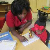 Deerwood KinderCare Photo #10 - Ms. Carrie is helping a child write the letters in the Preschool class