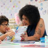 The IDEAL School of Manhattan Photo #4 - A kindergarten teacher helps a student with his reading.