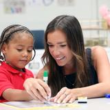 The IDEAL School of Manhattan Photo #15 - A teacher works with a kindergarten students on his letters