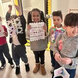 The IDEAL School of Manhattan Photo - Students show the kindness snowflakes that they made.
