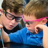 St. Joseph Catholic School Photo #7 - A kindergartner works with his 4th grade buddy in the science lab.