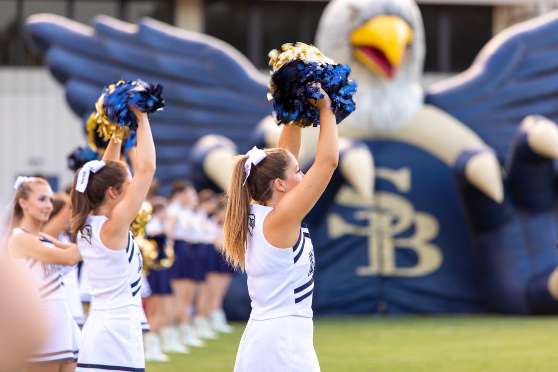 Second Baptist School Photo - Cheerleaders welcome the football players to the field prior to kick-off at the Second Baptist School football game.