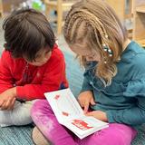 Indiana Montessori Academy Photo #2 - An IMA kindergarten student reads to a younger friend.