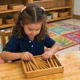 Montessori Children's Academy Photo #2 - A young girl carefully places wooden spindles into a counting box, practicing focus, order, and fine motor control. This Montessori material strengthens early math understanding, hand & eye coordination, and independence while nurturing calm concentration in a beautifully prepared learning environment.