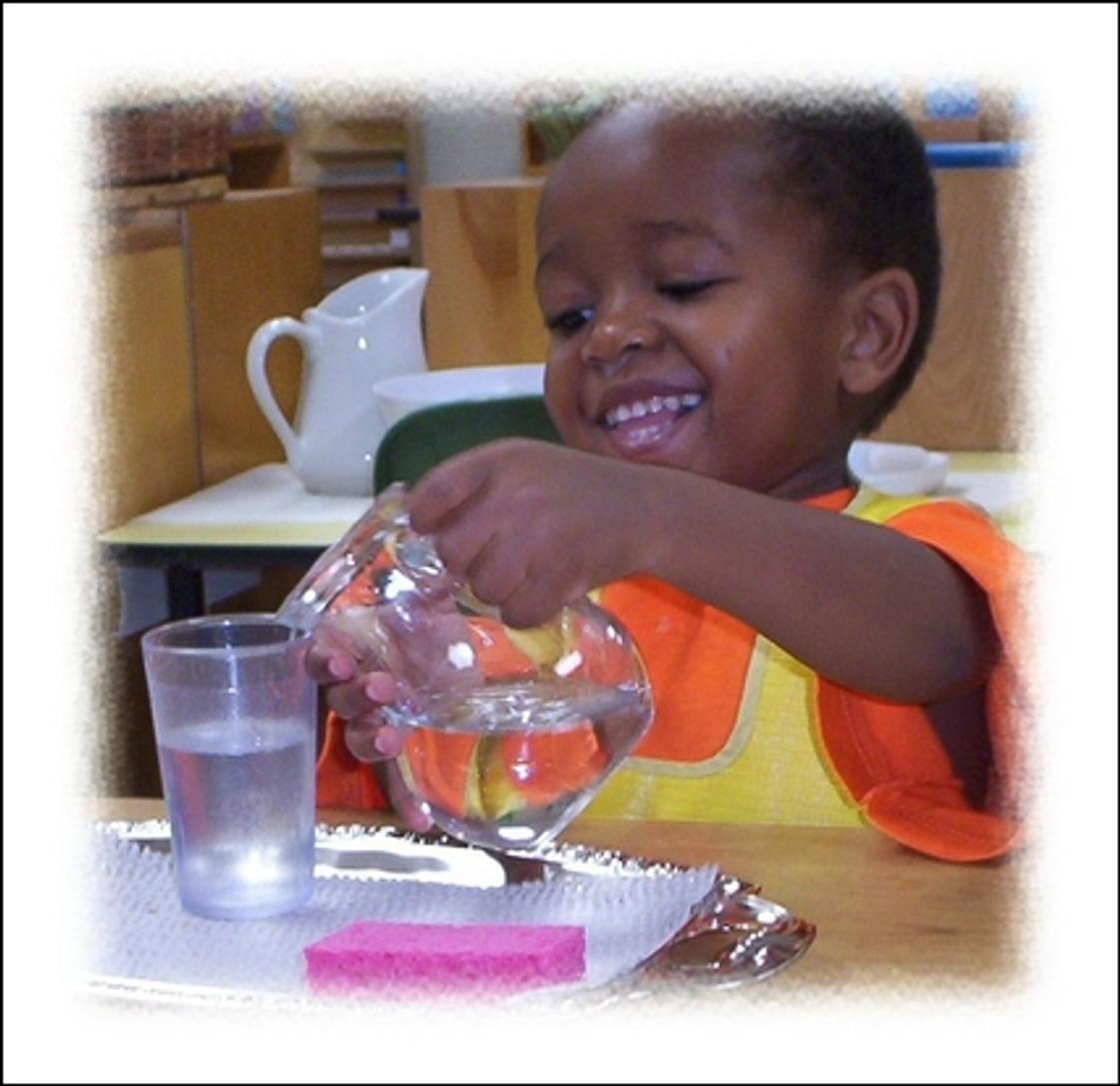 Oak Meadow Montessori School Photo - Children love the area of Practical Life in the Montessori classroom. This student is happily pouring water and learning fine muscle control and how to serve a beverage to his friends.