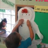 North Elston KinderCare Photo #8 - Putting faces on the Dress Me Dolls in the Prekindergarten Dramatic Play area.